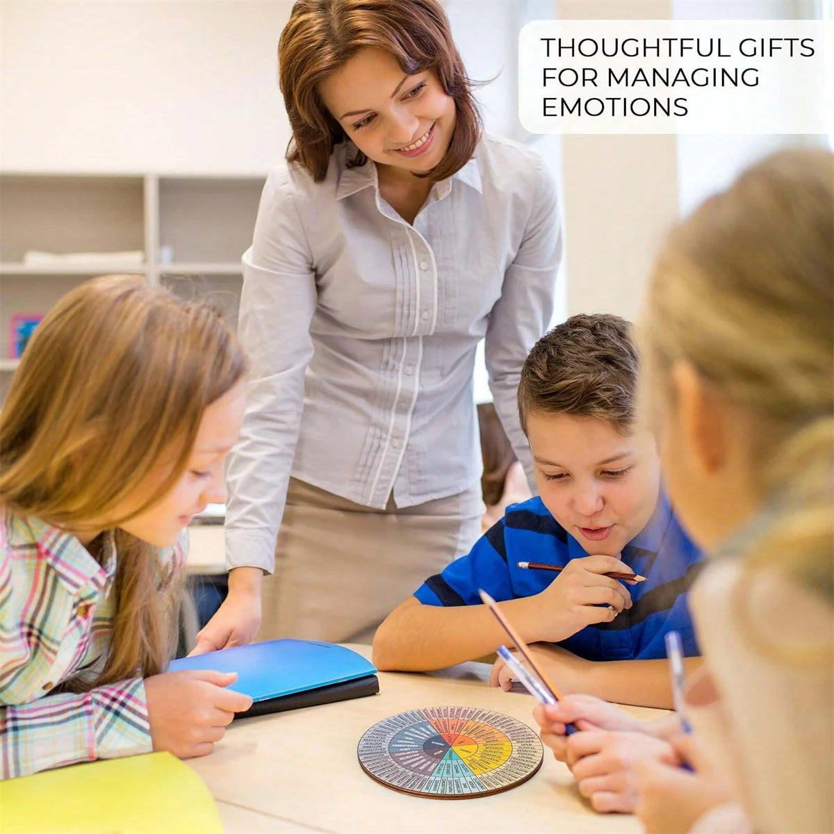 Feelings wheel chart used as mental health decor on a therapist’s desk beside notebooks and plants