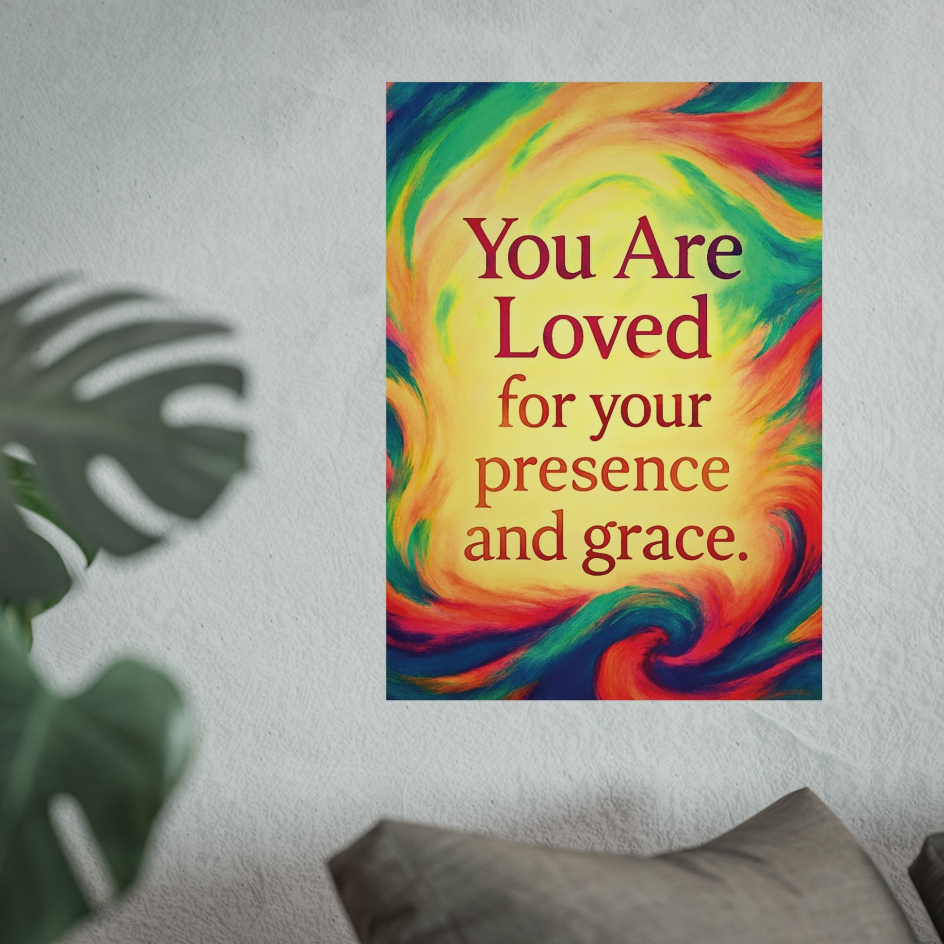 Colorful poster with motivational quote on a wall with a plant and pillow in the foreground