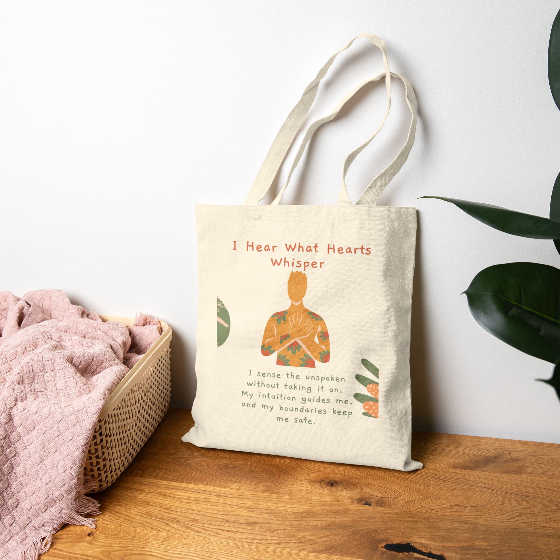 Tote bag with a design and text on a wooden surface with a white wall and plant in the background