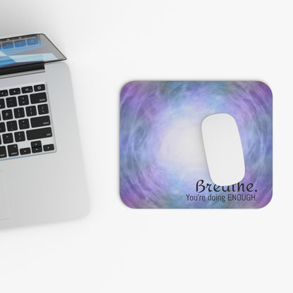 Laptop with a colorful mouse pad featuring text next to it on a white background