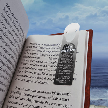 Open book with a bookmark featuring the text 'I AM BRAVE' against a scenic background.