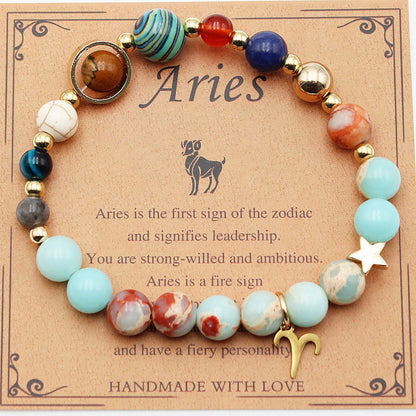 A colorful beaded bracelet representing the aries zodiac sign, displayed on a card with the text 'aries' and a brief description of the aries personality traits. The bracelet is made with a variety of beads and features a gold-tonearies symbol charm.